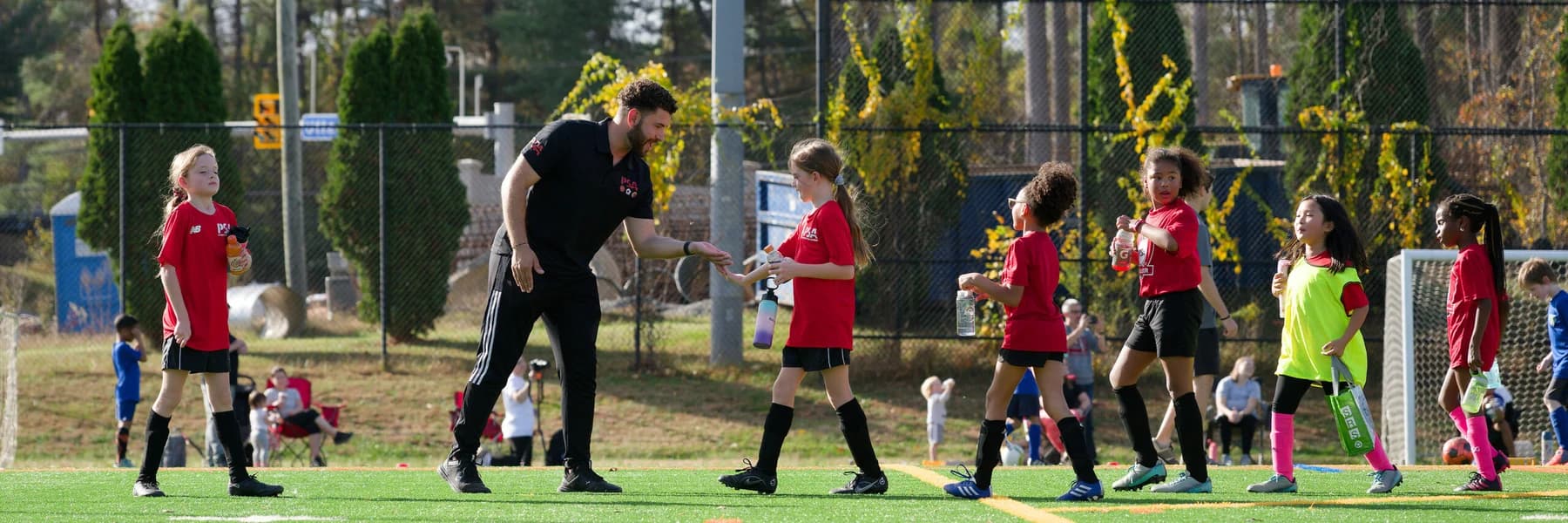 A coach encouraging a young soccer player on the field